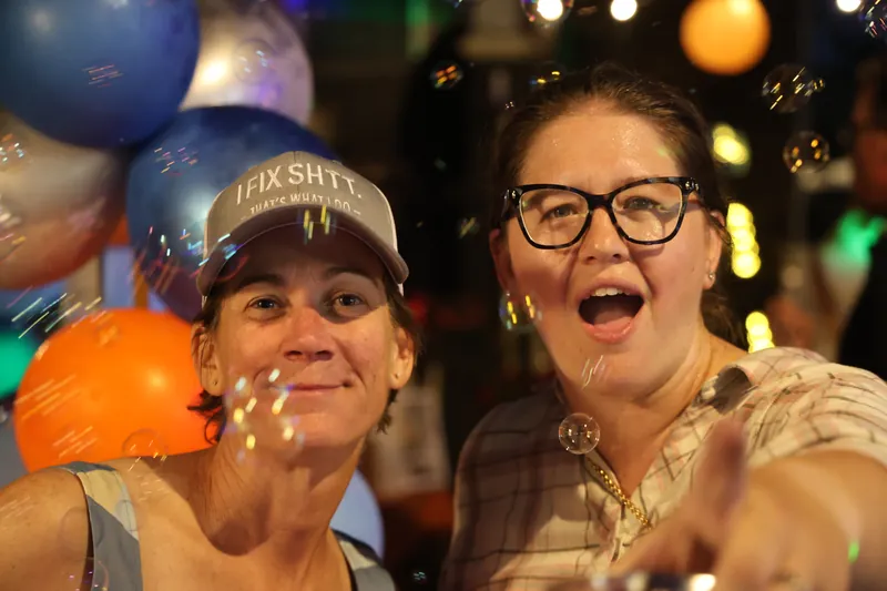 Two guests celebrating among balloons