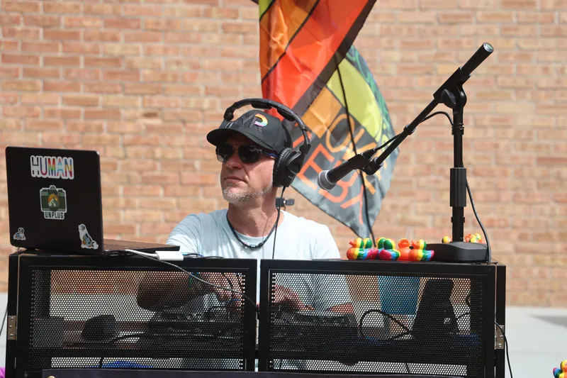 The DJ booth set up outdoors beside a rainbow flag