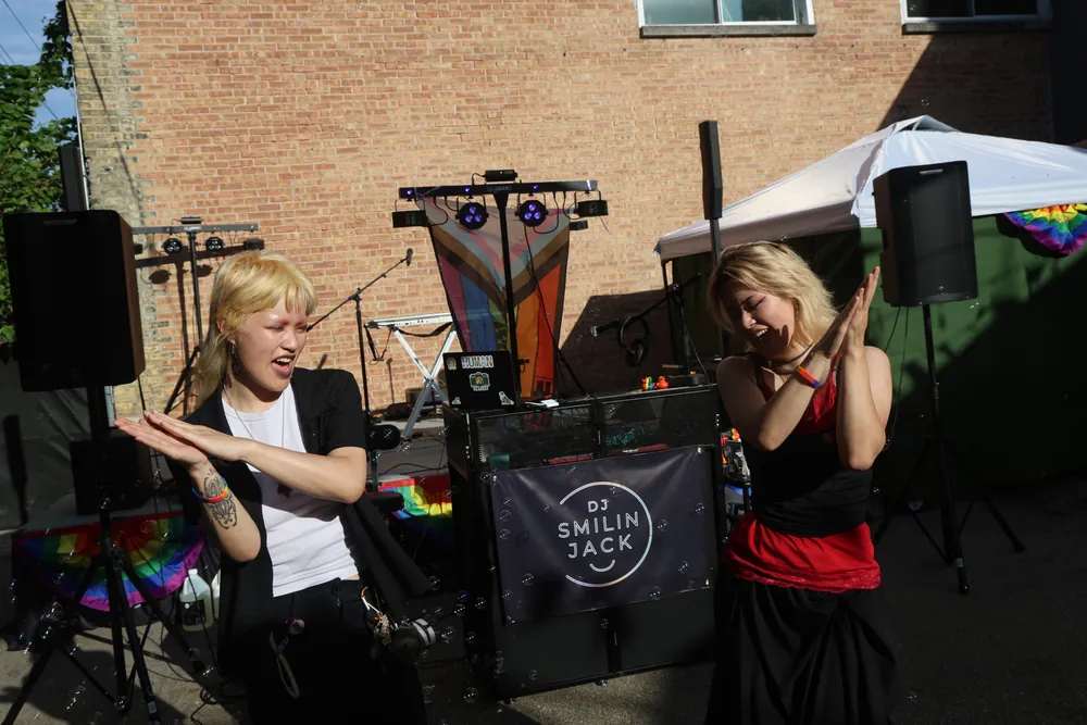 Guests dancing in front of the DJ Smilin' Jack booth and banner