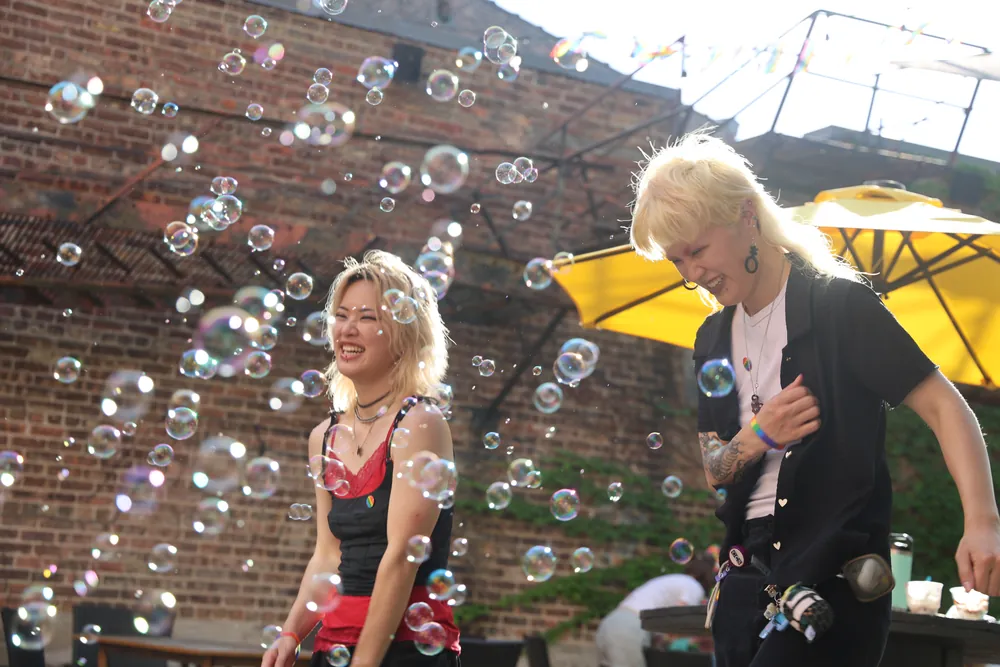 Guests dancing in a cloud of bubbles under yellow umbrellas